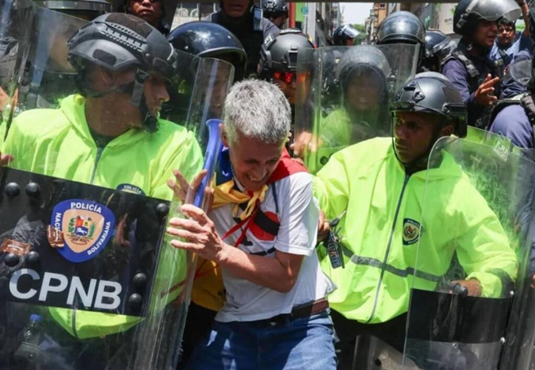 Fuerzas de seguridad bloquean el paso de manifestantes en Caracas, quienes denuncian la falta de voluntad política para resolver la crisis de ingresos básicos