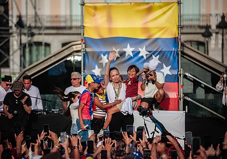 María Corina Machado abraza a varios niños en el escenario de la Puerta del Sol. (Tania Sieira)